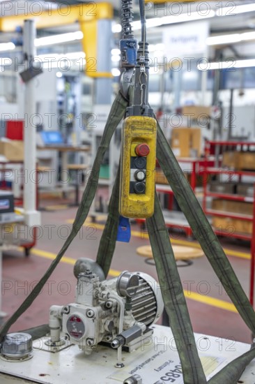 Yellow hoist with pulley block and ropes in an industrial workshop environment