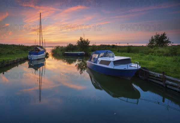 Sunset on the Achterwasser, boats moored in a small natural harbor, near Zinnowitz, Usedom island, Mecklenburg-Western Pomerania, Germany