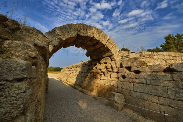 Crypt, vaulted entrance to the stadium, ancient stone arch with distinctive shadows along old walls under a clear sky, archaeological site, Ancient Olympia, Olympia, Peloponnese, Greece