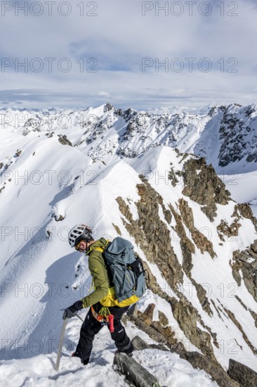 Mountaineer on the summit of Piz Grialetsch in winter, view of mountain panorama with snow, Grisons Haute Route, Albula Alps, Rhaetian Alps, Grisons, Switzerland
