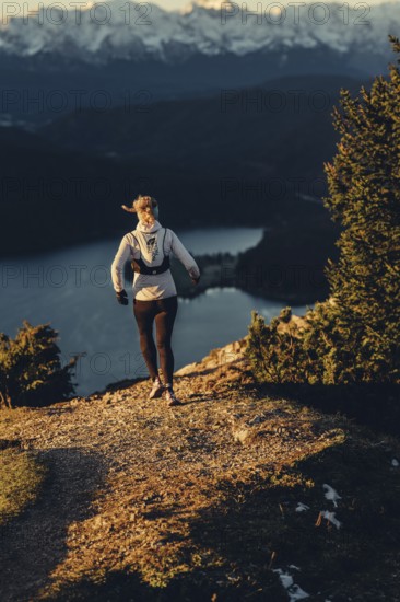Trail running in autumn on the Jochberg on Lake Walchensee against the wonderful backdrop of the Alps, Bavaria, Germany
