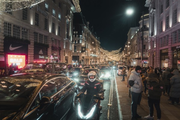 Busy street at night with traffic and brightly lit buildings and roads, New Year's Eve London, United Kingdom