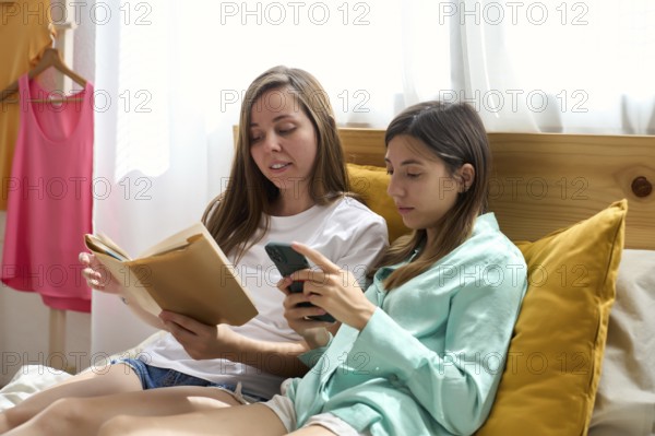 A lesbian couple relaxes in a cozy setting, reading and using a smartphone The scene captures intimacy and comfort, emphasizing LGBTQIA+ pride and love in everyday life