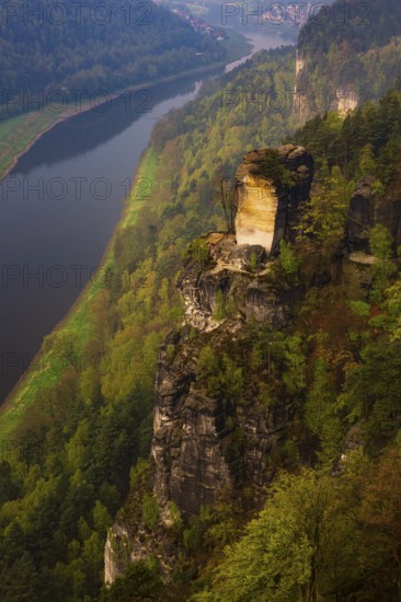 The bright lit Wartturm above the Elbe river seen from the Bastei rocks near the village of Rathen in Saxon Switzerland National Park, Saxony, Germany. On November 22, 2000 the Wartturm was the scene of a spectacular rockfall