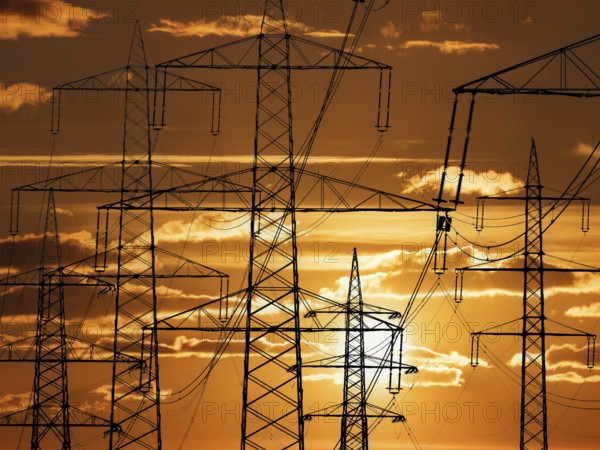 The mast of a high-voltage line in front of sunset, Lower Saxony, Federal Republic of Germany