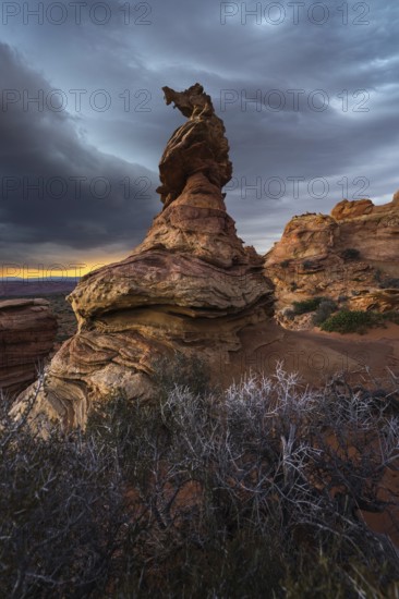 A stunning silhouette of a unique rock formation at Coyote Buttes in the Paria Canyon-Vermilion Cliffs Wilderness of Arizona, under a dramatic sunset sky