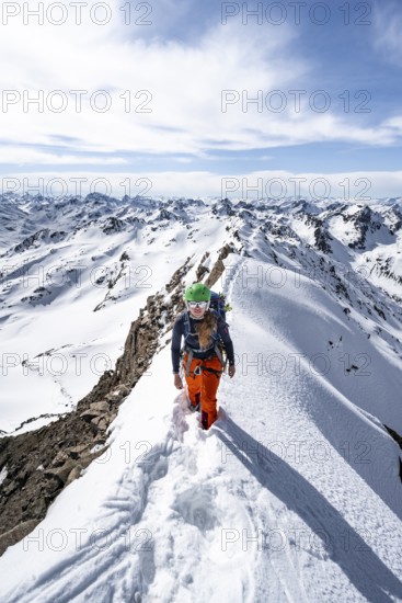 Mountaineer on a narrow mountain ridge in winter, summit of Piz Grialetsch, view of mountain panorama with snow, Grisons Haute Route, Albula Alps, Rhaetian Alps, Grisons, Switzerland