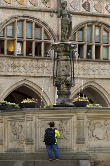 Historic market square with Roland fountain in front of the town hall and a person of small stature, Hildesheim, Lower Saxony, Germany