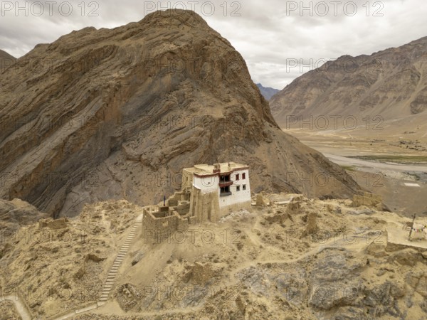 A solitary monastery nestled in the rugged mountains of the Zanskar Valley, Ladakh, India, captures the stark beauty and spiritual ambiance of this remote high altitude region