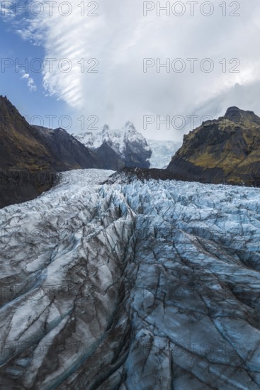 Stunning view of the expansive Vatnajökull Glacier, nestled within the rugged landscapes of Vatnajökull National Park in Iceland, showcasing intricate ice formations under a dramatic sky