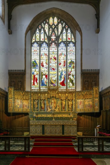 Stained glass east window, elaborately carved gilt altar reredos screen 1938, church of Saint John the Baptist, Peterborough, Cambridgeshire, England, UK