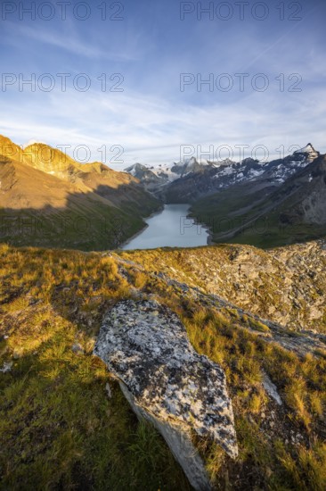Picturesque mountain landscape at the summit Mont de la Blana at sunset, view of blue mountain lake, reservoir Lac des Dix and summit Mont Blanc de Cheilon with glacier, Hérémence, Valais, Western Alps, Switzerland