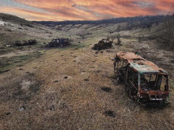 From above, this image captures the harsh reality of war in Ukraine, showing several burned out vehicles scattered across a desolate landscape