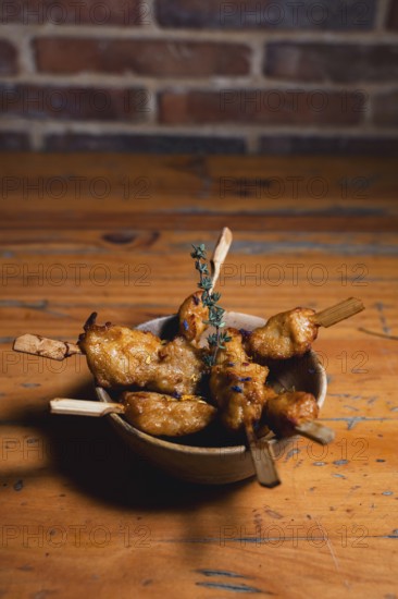 Juicy chicken tenderloin skewers, lightly seasoned and infused with aromatic herbs, presented on a rustic wooden plate. Perfect for a tasty and casual dining experience