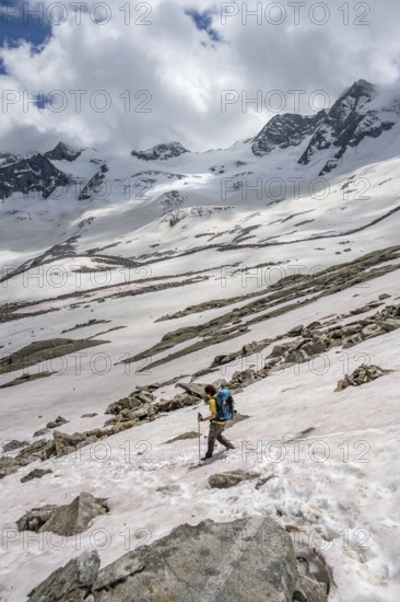 Mountaineer on a snowfield, descent from the summit of Schönbichler Horn, view of snow-covered and glaciated mountain landscape with summit Großer Möseler, Berliner Höhenweg, Zillertal Alps, Tyrol, Austria