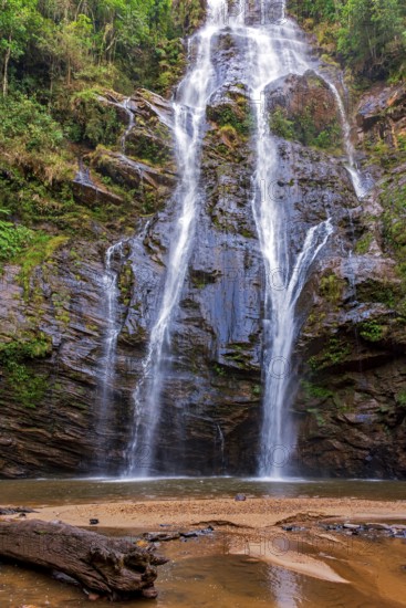 Waterfall over moss-covered rocks and tropical forest vegetation in the state of Minas Gerais, Minas Gerais, Brazil