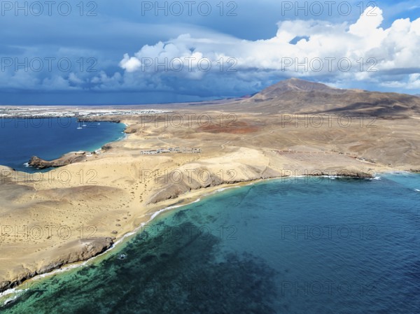 Coast with Playa Caleta del Congrio beach and blue sea, arid landscape of Los Ajaches Natural Park, aerial view, Lanzarote, Canary Islands, Spain