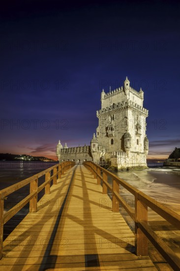 Belem Tower or Tower of St Vincent, famous tourist landmark of Lisboa and tourism attraction, on the bank of the Tagus River (Tejo) after sunset in dusk twilight with dramatic sky. Lisbon, Portugal