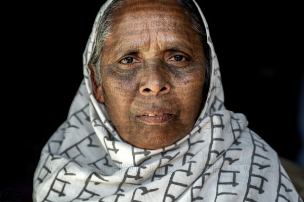 Portrait of a woman from the Ramnami caste (Chhattisgarh, India), As a sign of devotion, Ramnami people used to tattoo their body and their face with the name of Rama, one of the main hindu god. Nowadays, this tradition is disappearing. Indeed, few of them are still tattooed, the younger generation fearing discrimination. The caste (or sect) is born in the end of the 19th century as a way to protest against the supremacy of the higher classes in the hindu hierarchical system. Comprised of low caste hindus, they dont accept the caste system, they practise a form of bhakti (devotion) dedicated to the god Rama