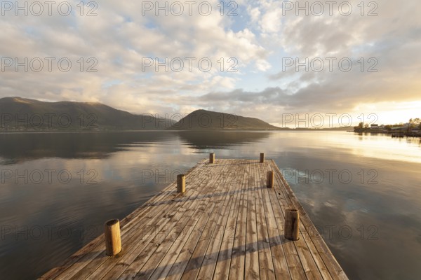 Golden hour light over the harbor and mountains. Summer sunset, Rosendal Port, Vestland, Norway