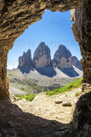Tre cime di lavaredo peaks viewed from a Tre Cime Cave entrance in the dolomites, italy, during a sunny summer day