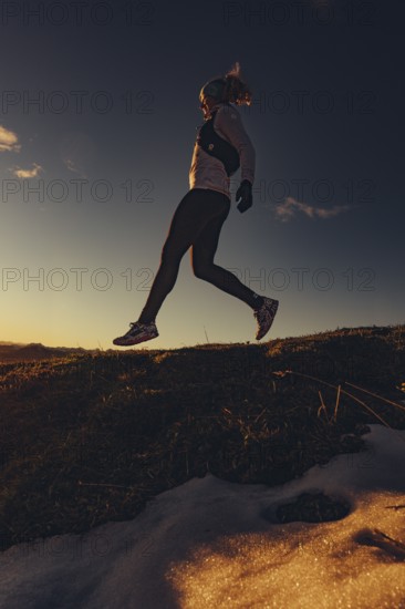 Trail running in autumn on the Jochberg on Lake Walchensee against the wonderful backdrop of the Alps, Bavaria, Germany