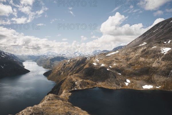 A stunning scene of interconnected mountain lakes surrounded by rugged peaks in Norway The expansive view captures the essence of the Nordic wilderness under a brilliant sky