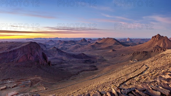 Vast desert landscape at sunset with mountain ranges on the horizon, The landscape of the Ahaggar Mountains in the Sahara in Algeria