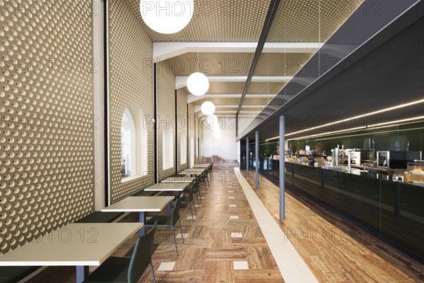 A stylish bar interior featuring geometric wall patterns, a sleek bar, and modern lighting, creating an inviting atmosphere with polished wooden floors and minimalist tables