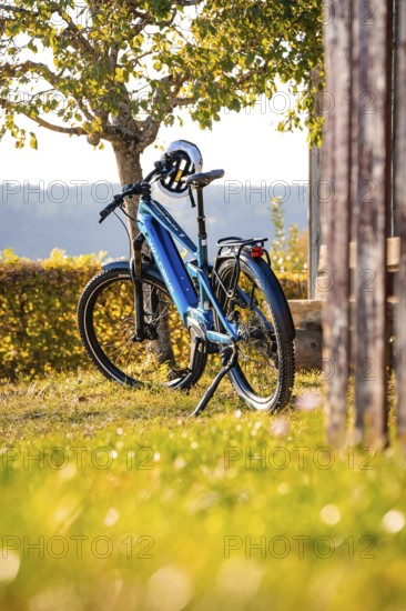 A bicycle with helmet standing next to a tree in a rural area, e-bike, forest bike, Calw, district of Calw, Black Forest, Germany