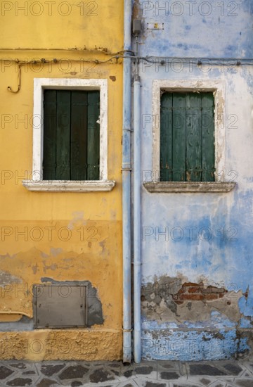 Blue and yellow house facade with windows, colourful houses on the island of Burano, Venice, Veneto, Italy