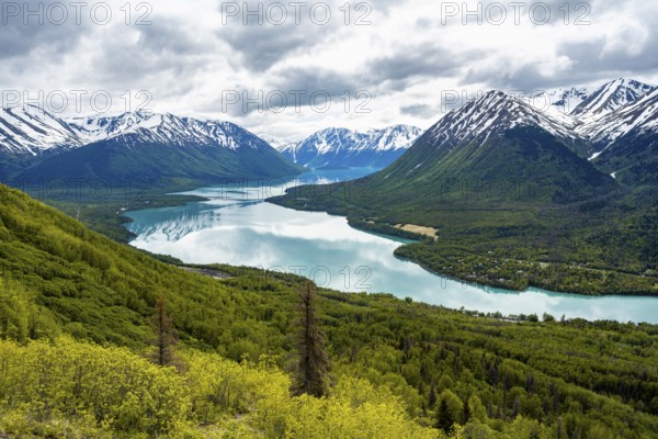 View of snowy mountains in spring and turquoise blue Kenai Lake, Slaughter Ridge Trail, Cooper Landing, Kenai Peninsula, Alaska, USA