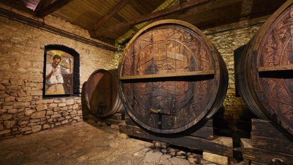 Wooden barrels in a historic wine cellar with painted wall decoration, Achaia Clauss winery, Patras, Peloponnese, Greece