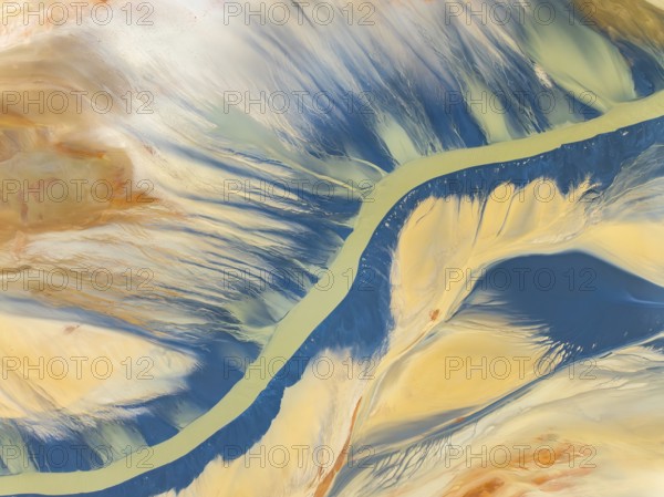 From above, this striking aerial shot captures vibrant natural textures and a sinuous river amidst earthy tones. The image, perfect for backgrounds or thematic designs, showcases the beauty and complexity of abstract landscapes