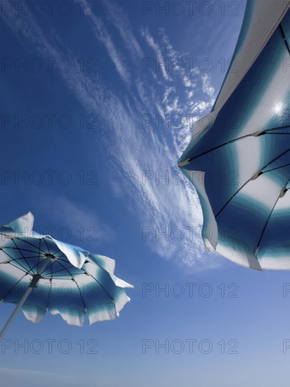 Parasols in front of a blue sky with clouds
