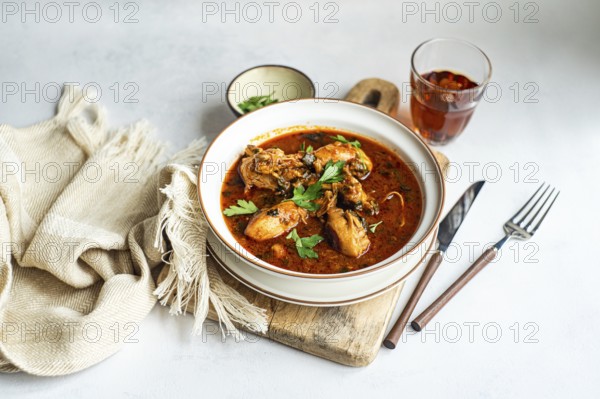 Savor this authentic Georgian chakhokhbili, a hearty chicken stew cooked in rich tomato sauce, seasoned with paprika, and garnished with fresh coriander leaves. Perfect comfort food