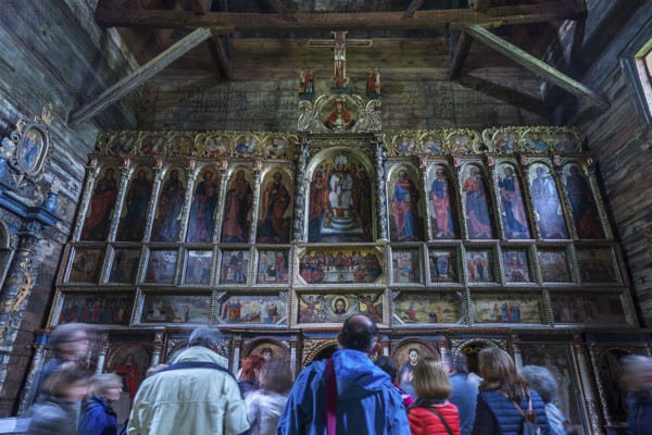 Orthodox chancel painted with iconostases, 16th century Gothic wooden church of St. Paraskevi, with a tour group in front, Radruz, Poland