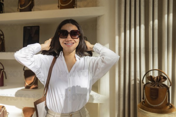 A smiling customer in a white shirt and sunglasses explores a chic bag store. Display shelves showcase an array of stylish bags brightly lit in the background