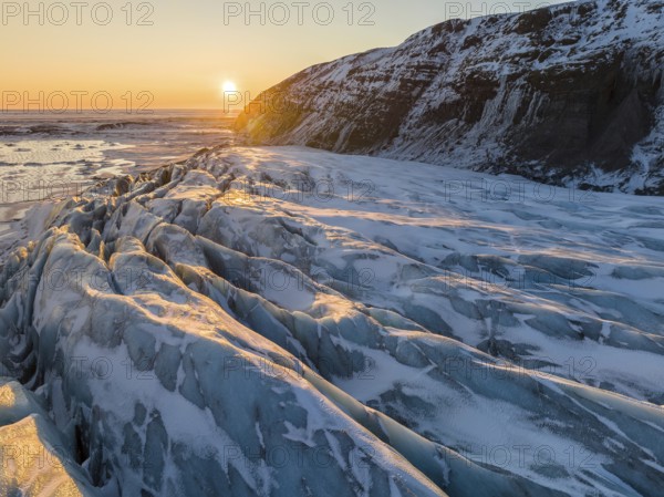 Breathtaking beauty of Glacier in Skaftafell under a golden winter sunrise. The scene captures the icy allure of Iceland with serene landscapes and majestic hues