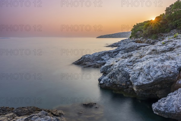 Crystal clear and turquoise water on the beach of Ustrine Bay on a sunny day at sunset on the island of Cres, long exposure, Croatia