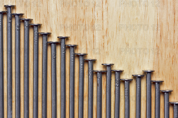 Declining Graph of Nails on a Wood Background