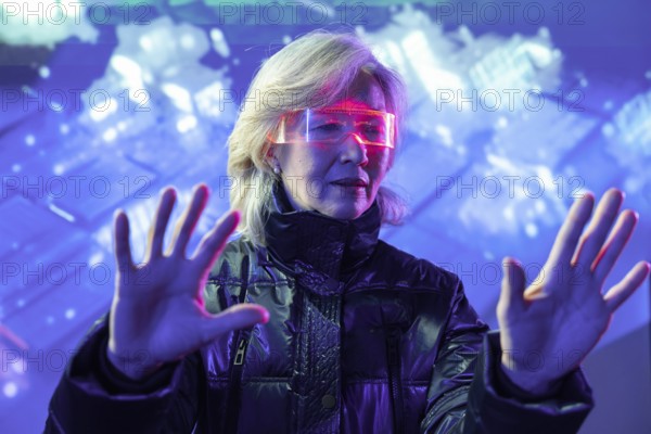 An elderly Asian woman interacts with virtual elements in the metaverse, wearing futuristic glasses and gesturing with her hands, surrounded by abstract elements