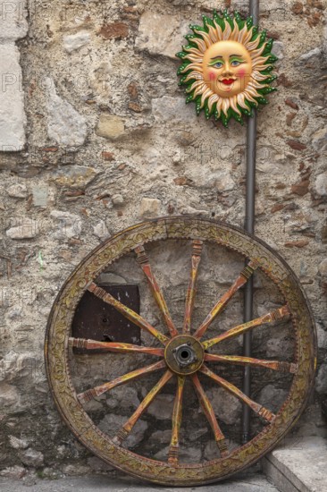 Wheel of a Sicilian cart, Italian Carretto siciliano, Sicilian Carrettu sicilianu and a typical ceramic, Taormina, Sicily, Italy