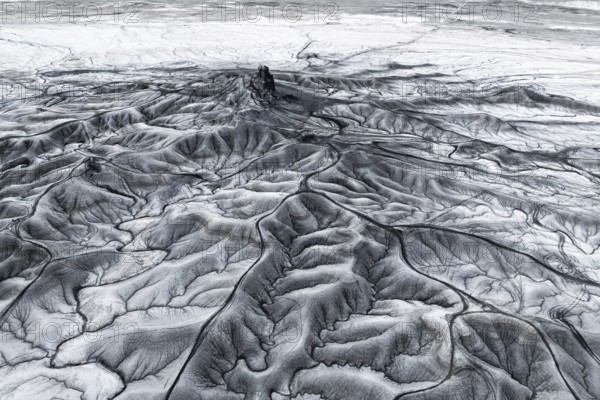 Aerial view of Moonscape Overlook in Utah showcasing intricate erosion patterns and stark geological textures in a barren landscape. The play of light and shadow emphasizes the rugged terrain and delicate formations typical of desert topography