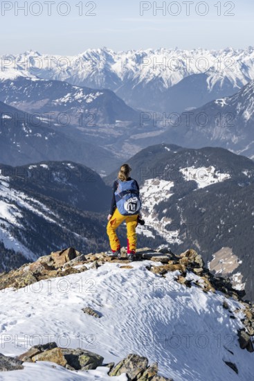 View of the Inn Valley, mountaineer at the summit of the Pirchkogel, mountains in winter, Sellraintal, Kühtai, Tyrol, Austria