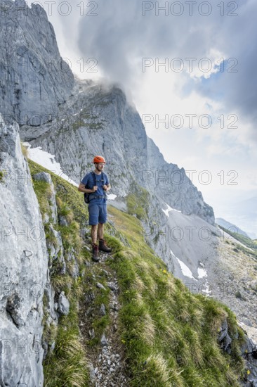 Mountaineer with helmet on a narrow hiking trail, ascent to the Ackerlspitze, Wilder Kaiser, Kaiser Mountains, Tyrol, Austria
