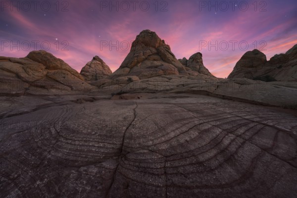 Majestic view of Coyote Buttes in the Paria Canyon-Vermilion Cliffs Wilderness, Arizona, featuring striking rock formations under a vibrant twilight sky