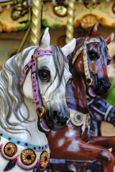 Two horse figures, horse heads, horses in a nostalgic children's carousel, close-up, France