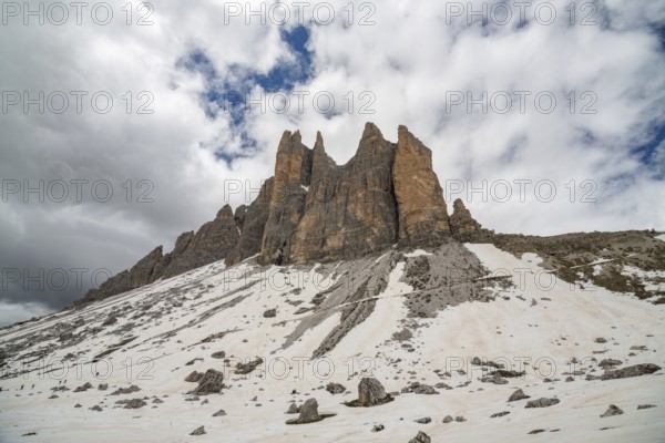 The majestic peaks of Tre cime di Lavaredo rise against a dramatic sky in the Dolomites mountains, Italy, showcasing nature's grand and rugged beauty in this breathtaking landscape