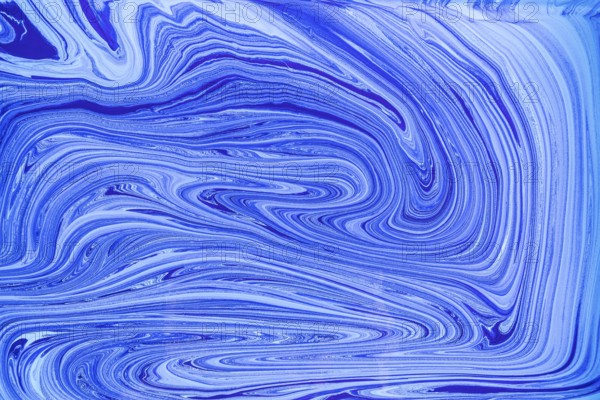 This image showcases a pattern of blue and white acrylic paint swirls resembling marble. The fluid, abstract design creates a sense of motion and elegance, perfect for artistic projects